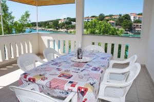 a table and chairs on a balcony with a view of the water at SeaSide VARSAN in Borovići