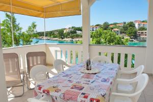 einen Tisch und Stühle auf einem Balkon mit Blick auf das Wasser in der Unterkunft SeaSide VARSAN in Borovići