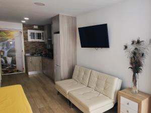 ベナルマデナにあるDeluxe Studio Herculesのリビングルーム(白いソファ、壁掛けテレビ付)