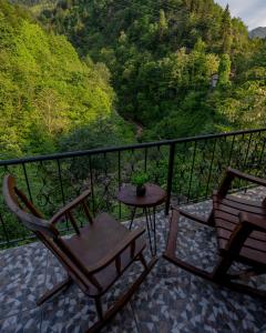 Un balcón con 2 sillas y una mesa con vistas. en bungalove tatil köyü, en Çamlıhemşin