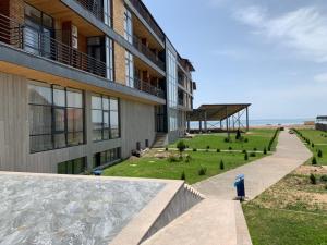 a building with a walkway next to a field of grass at Vzmorie Resort Hotel in Bosteri