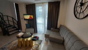 a living room with a couch and a clock on the wall at Furnished apartment in Damac Tower. Jordan in Amman