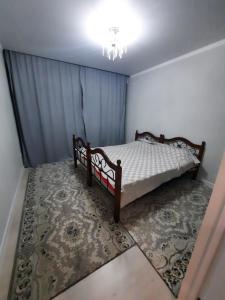 um quarto com uma cama de madeira e um tapete em Жк Сити плюс em Almaty