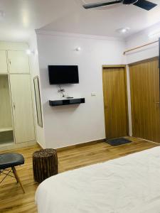 een kamer met een bed en een tv aan de muur bij Mrig Valley Resort, Homestay & Banquet in Kandikhal