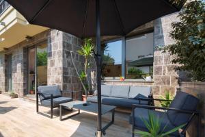 a patio with two chairs and an umbrella at Hotel Vladimir in Budva
