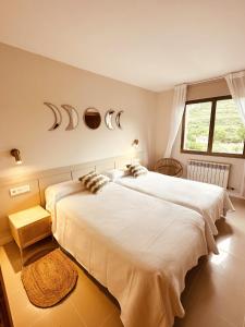 a bedroom with two beds and a window at Hostal Lóbrega in Torrecilla en Cameros