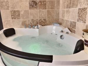 een badkamer met een bad gevuld met water bij Appartement Balnéo in Villeneuve