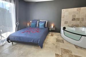 een slaapkamer met een bed met een bad en een sidx sidx bij Appartement Balnéo in Villeneuve