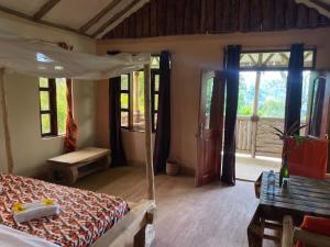 a bedroom with a bed with a canopy and a window at Bwindi my home 