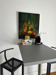 einen Tisch in einem Raum mit einem Gemälde an der Wand in der Unterkunft Großzügige 3-Zimmer Altbauwohnung in Kiel