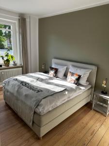 a bedroom with a large bed with two pillows at Großzügige 3-Zimmer Altbauwohnung in Kiel