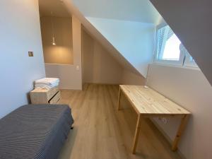 Zimmer mit einem Bett, einem Tisch und einem Fenster in der Unterkunft Urbas Sea view apartment in Nida