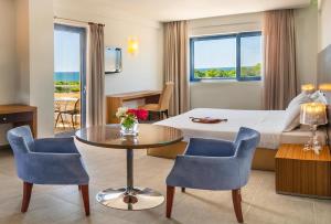 a hotel room with a bed and a table and chairs at Ionian Theoxenia in Kanali