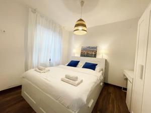 a bedroom with a white bed with towels on it at Apartments Monika Bed & Breakfast in Punat