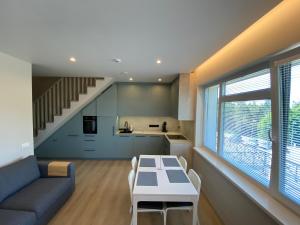 eine Küche und ein Wohnzimmer mit einem Tisch und einem Sofa in der Unterkunft Urbas Sea view apartment in Nida