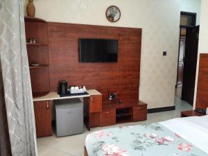 a bedroom with a tv on a wooden wall at Casabonita Villas in Kampala