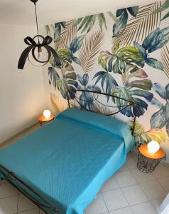 ein blaues Bett in einem Zimmer mit Wandbild in der Unterkunft Nyx Dea Della Notte in Bari