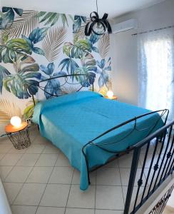 ein Schlafzimmer mit einem Bett mit einer blauen Decke in der Unterkunft Nyx Dea Della Notte in Bari