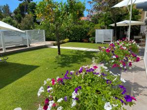 un giardino con fiori viola e bianchi in un cortile di Casa Mar - B&B - a Terracina