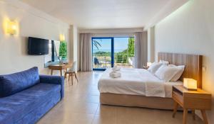Habitación de hotel con cama y sofá azul en Ionian Theoxenia, en Kanali