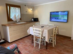 a kitchen with a table and a tv on the wall at Rivolta home in Buti