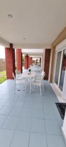 a patio with a white table and chairs on it at Bungalow White Apartments in Polykhrono