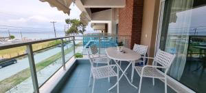 a balcony with a table and chairs on a balcony at Bungalow White Apartments in Polykhrono