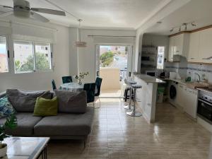 een woonkamer met een bank en een tafel bij Sea-view 3-bedroom apartment near Alicante in Arenales del Sol