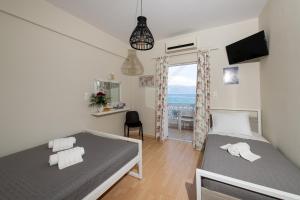 una camera con due letti e vista sull'oceano di Moukas Seaside Apartments Romantico a Selianitika