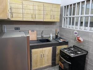 a kitchen with a sink and a stove at Appartement Kekely in Lomé