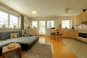 een woonkamer met een bank en een keuken bij Alpen Appartements MOIGG in Mayrhofen