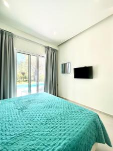a bedroom with a green bed and a window at Splash Suites with Private Pools in Nikiana