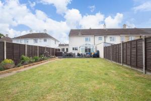 a large yard in front of a house with a fence at Modern Three Bedroom Home in Gloucester with Hot Tub in Gloucester