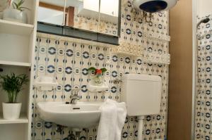 un baño con lavabo y espejo en Al Sole di TSS' - Cozy Apartment a 20 Metri dal Lago di Caldonazzo - Perfetto per coppie a Calceranica al Lago, en Calceranica al Lago 10 fotos más