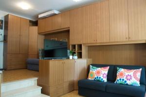 Una sala de estar con un sofá y un televisor de pantalla plana. en Al Sole di TSS' - Cozy Apartment a 20 Metri dal Lago di Caldonazzo - Perfetto per coppie a Calceranica al Lago, en Calceranica al Lago