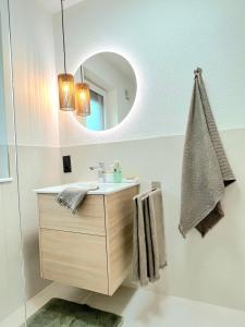 ein Bad mit einem Waschbecken und einem Spiegel in der Unterkunft Maison Saarschleife Mettlach in Mettlach