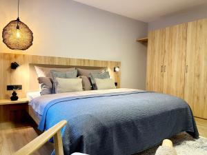 ein Schlafzimmer mit einem großen Bett mit einer blauen Decke in der Unterkunft Maison Saarschleife Mettlach in Mettlach