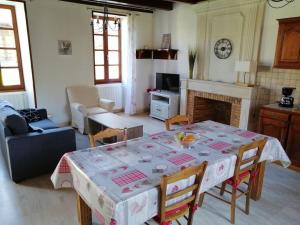 a living room with a table and a fireplace at Maison charentaise in Pons