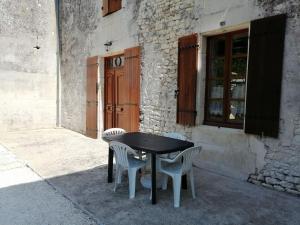 a black table and chairs in front of a building at Maison charentaise in Pons