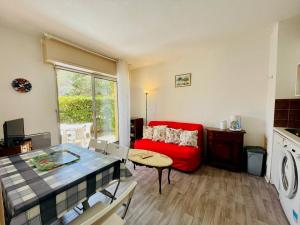 ein Wohnzimmer mit einem roten Sofa und einem Tisch in der Unterkunft Appartement Arcachon, 2 pièces, 4 personnes - FR-1-433-13 in Arcachon