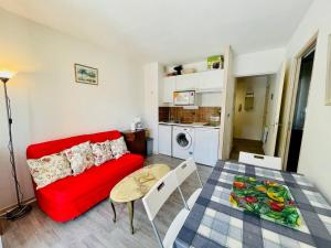 ein Wohnzimmer mit einem roten Sofa und einem Tisch in der Unterkunft Appartement Arcachon, 2 pièces, 4 personnes - FR-1-433-13 in Arcachon