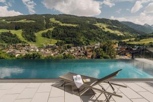 a chair sitting on a patio next to a swimming pool at Apartmentresort MyLodge in Schladming