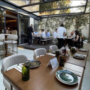 a group of people sitting at tables in a restaurant at Shepherd Hotel in Amman