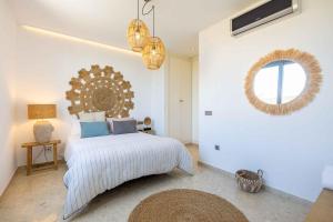 een slaapkamer met een bed en een spiegel aan de muur bij La Savina House 2 in La Savina