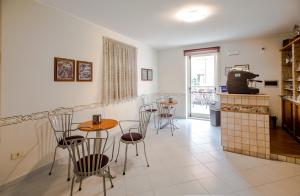 Albergo Il Veliero في بينيتو: غرفة بها طاولات وكراسي ومطبخ