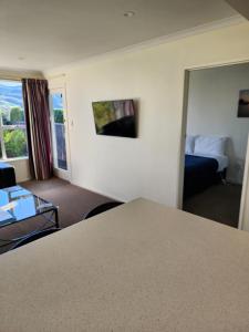 ein Hotelzimmer mit einem Bett und einem Wohnzimmer in der Unterkunft Roslyn Sanctuary Hereford St Dunedin in Dunedin