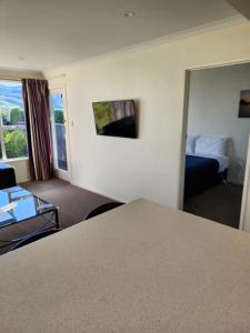 Habitación de hotel con cama y sala de estar. en Roslyn Sanctuary Hereford St Dunedin, en Dunedin