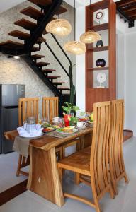 a dining room with a wooden table and chairs at Sudha Villa Bali Anyelir in Seminyak