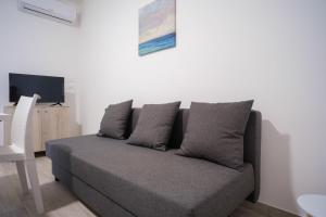 un divano in soggiorno con TV di Case bianche del Capitolo a Monopoli