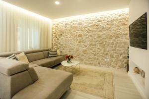 a living room with a couch and a stone wall at ANNO Apartment Imotski-Makarska in Imotski